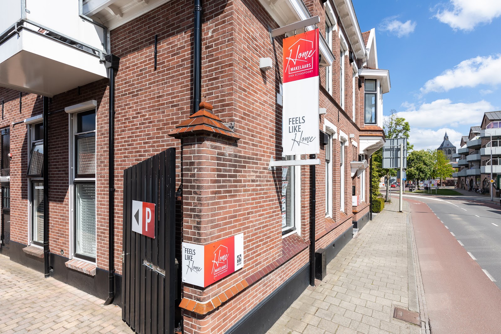 Bakstenen kantoorpand van Home Makelaars met Feels Like Home vlag